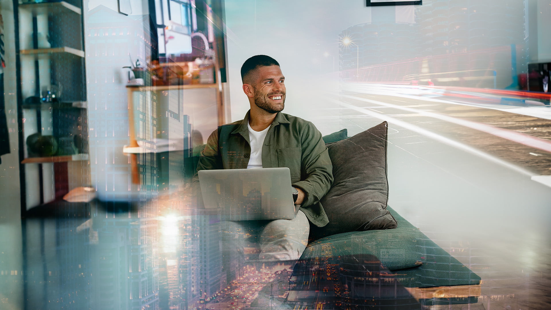 Man som sitter i soffa med laptop i när och ler utan att titta in kameran