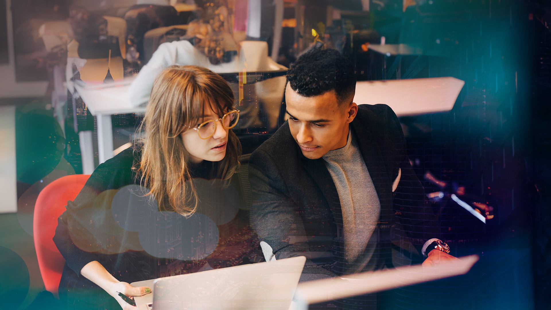 Man och kvinna som sitter och jobbar ihop med laptop framför sig