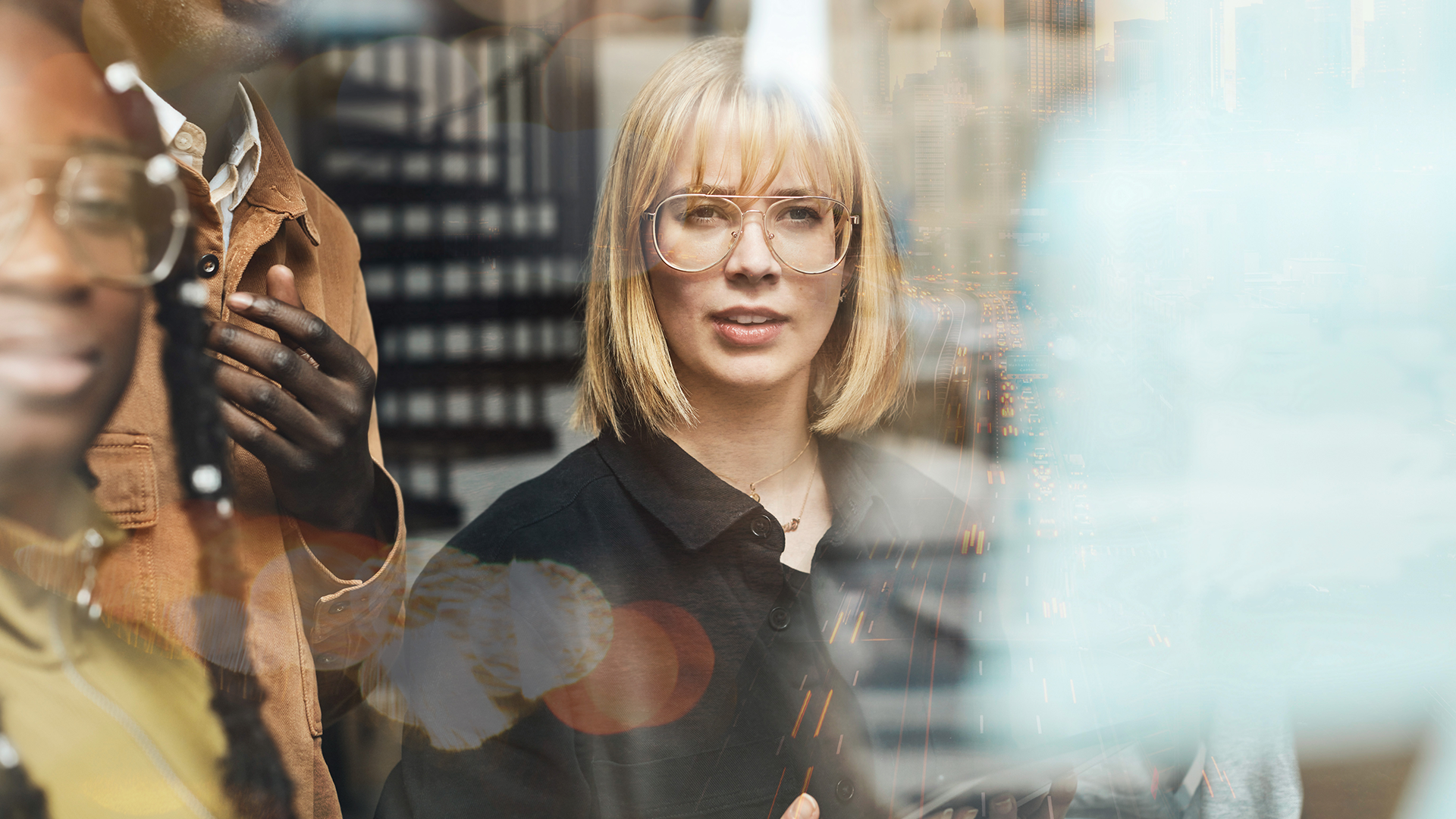 Vit kvinna med svart skjorta och glasögon som tittar framåt i bilden