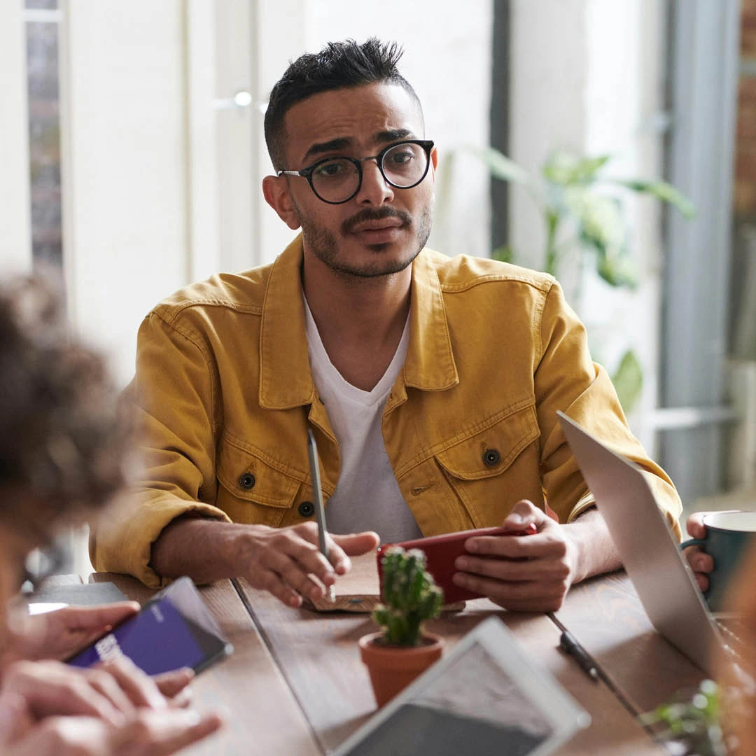 Man i gul jacka deltar i möte om kriskommunikation – Sälj & Marknadshögskolan Upskill & Reskill