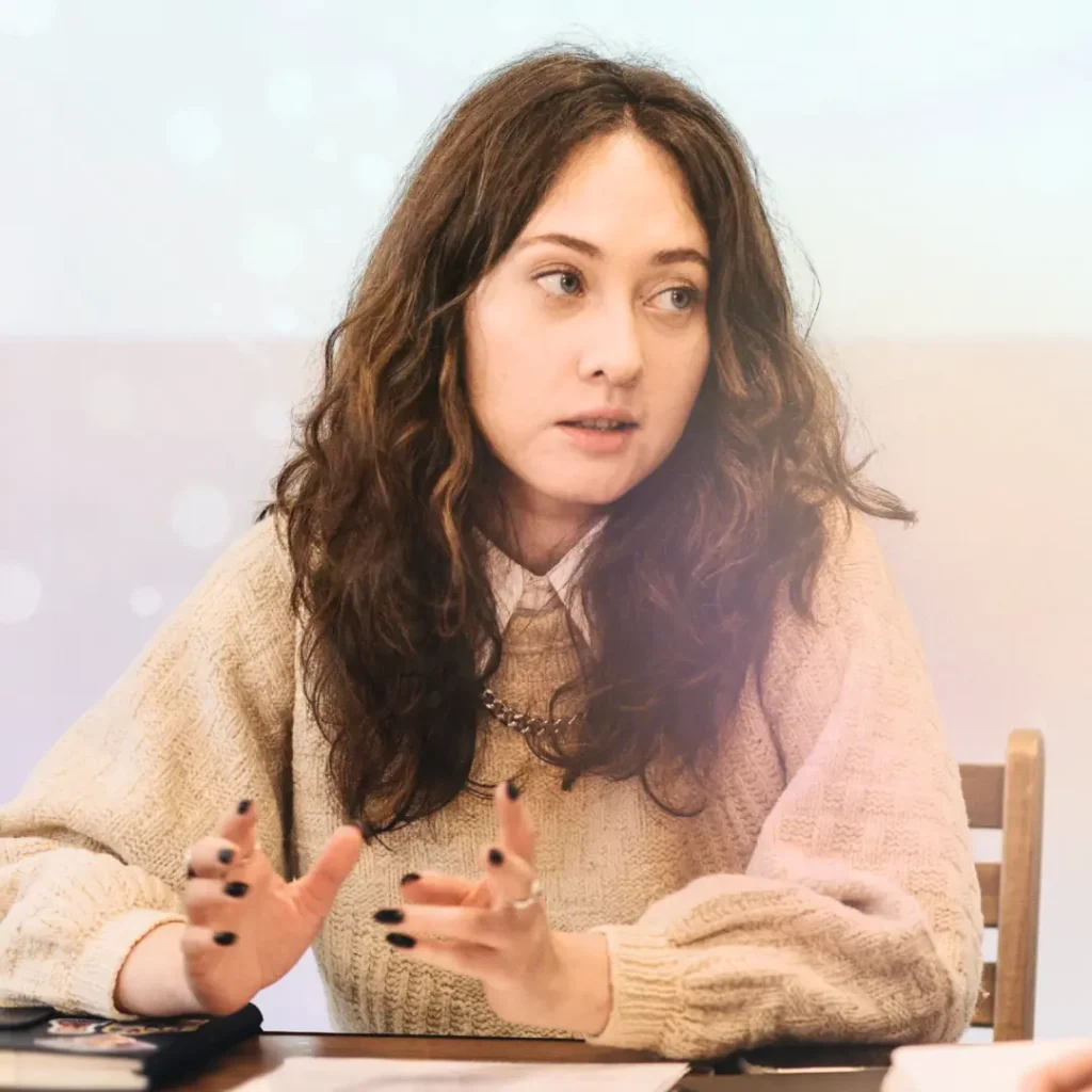 Bild på kvinna med bekymrad blick, som sitter i ett möte. Från kursen i konflikthantering